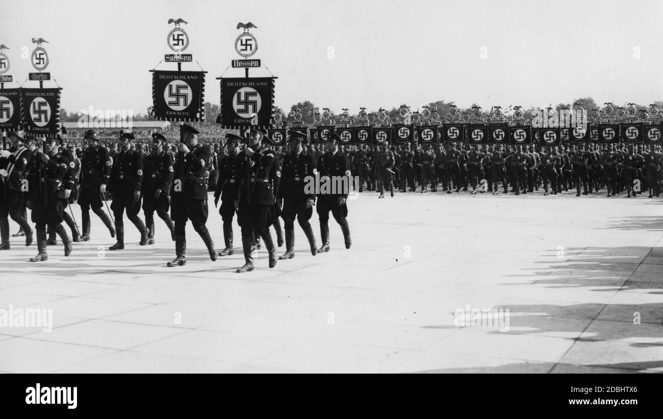 Die Standardträger der SS (vorne) und SA (hinten) marschieren in der Luitpoldarena auf dem Parteigelände Nürnberg hinauf. Von links: Adolf Hitler, Berlin, Sachsen, Hessen. Stockfoto