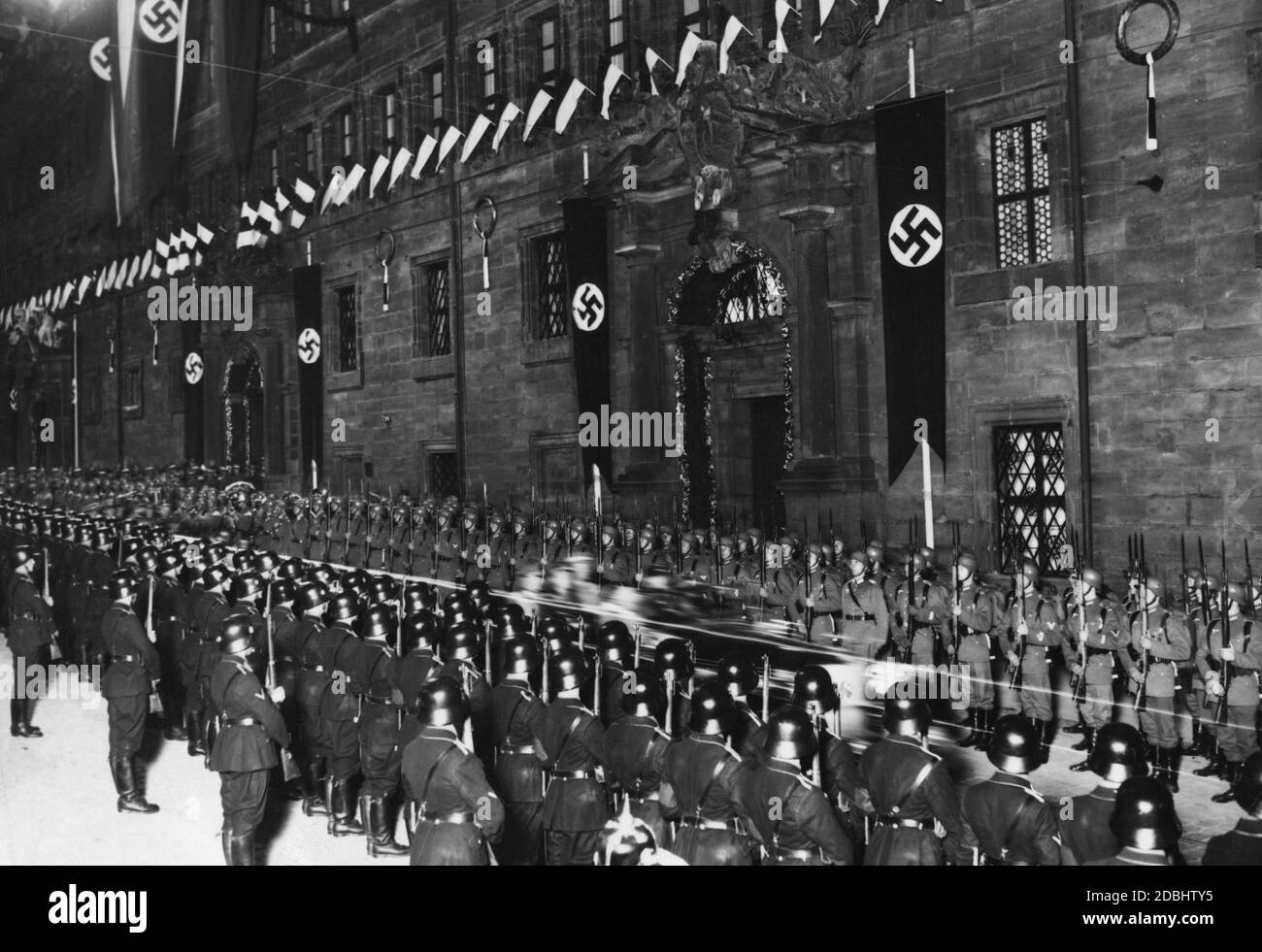 Truppen der Reichswehr und der Leibstandarte-SS stehen vor der Aufnahme des Reiches und der Parteiführung durch die Stadt Nürnberg im Rathaus von Angesicht zu Angesicht. Stockfoto