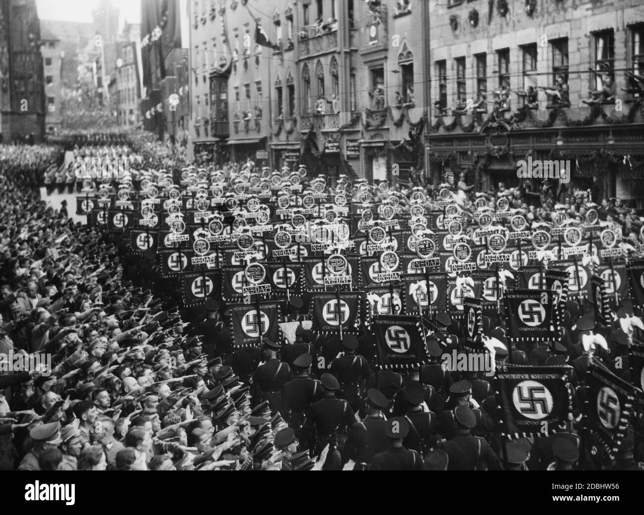 Auf dem Weg zum sogenannten Adolf-Hitler-Platz marschieren die Formationen der SS-Standartträger durch die Straßen Nürnbergs, von den Nürnberger Menschen begrüßt. Stockfoto