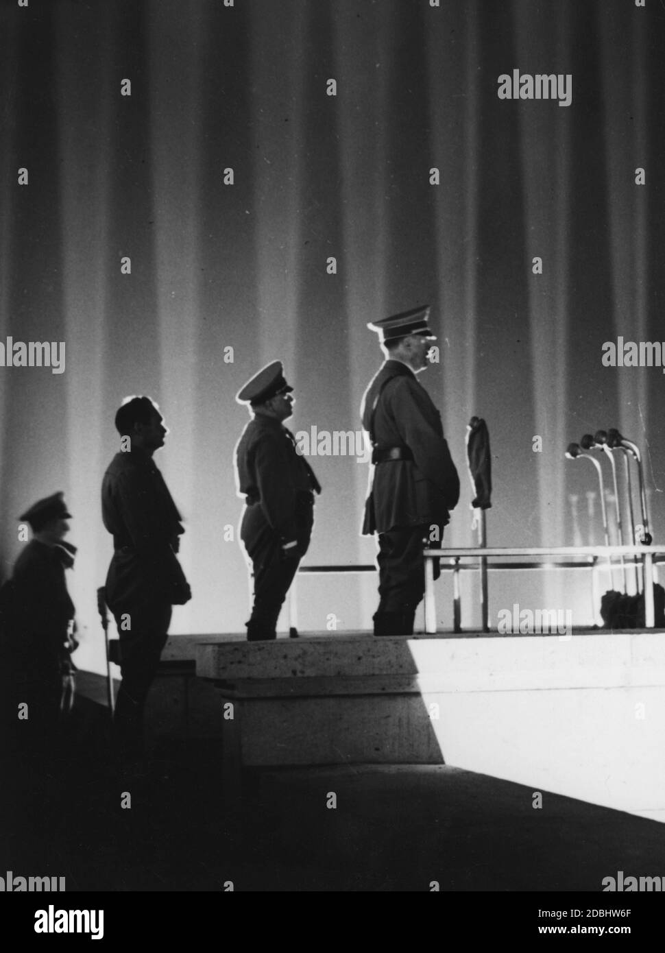 Adolf Hitler inspiziert die politischen Führer der NSDAP auf dem Zeppelinfeld, links Robert Ley und Rudolf Hess. Im Hintergrund die Lichtdom mit 130 Flak-Suchscheinwerfern. Stockfoto