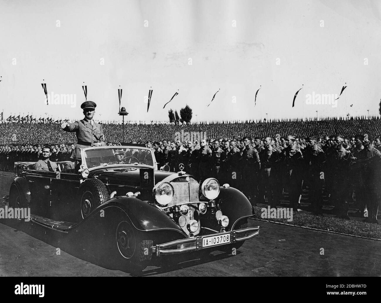 Blick auf den Abgang Adolf Hitlers aus dem Stadion der Hitlerjugend, wo die Parade der Hitlerjugend stattfand. Rudolf Hess sitzt hinter ihm im Mercedes 770 K. Stockfoto