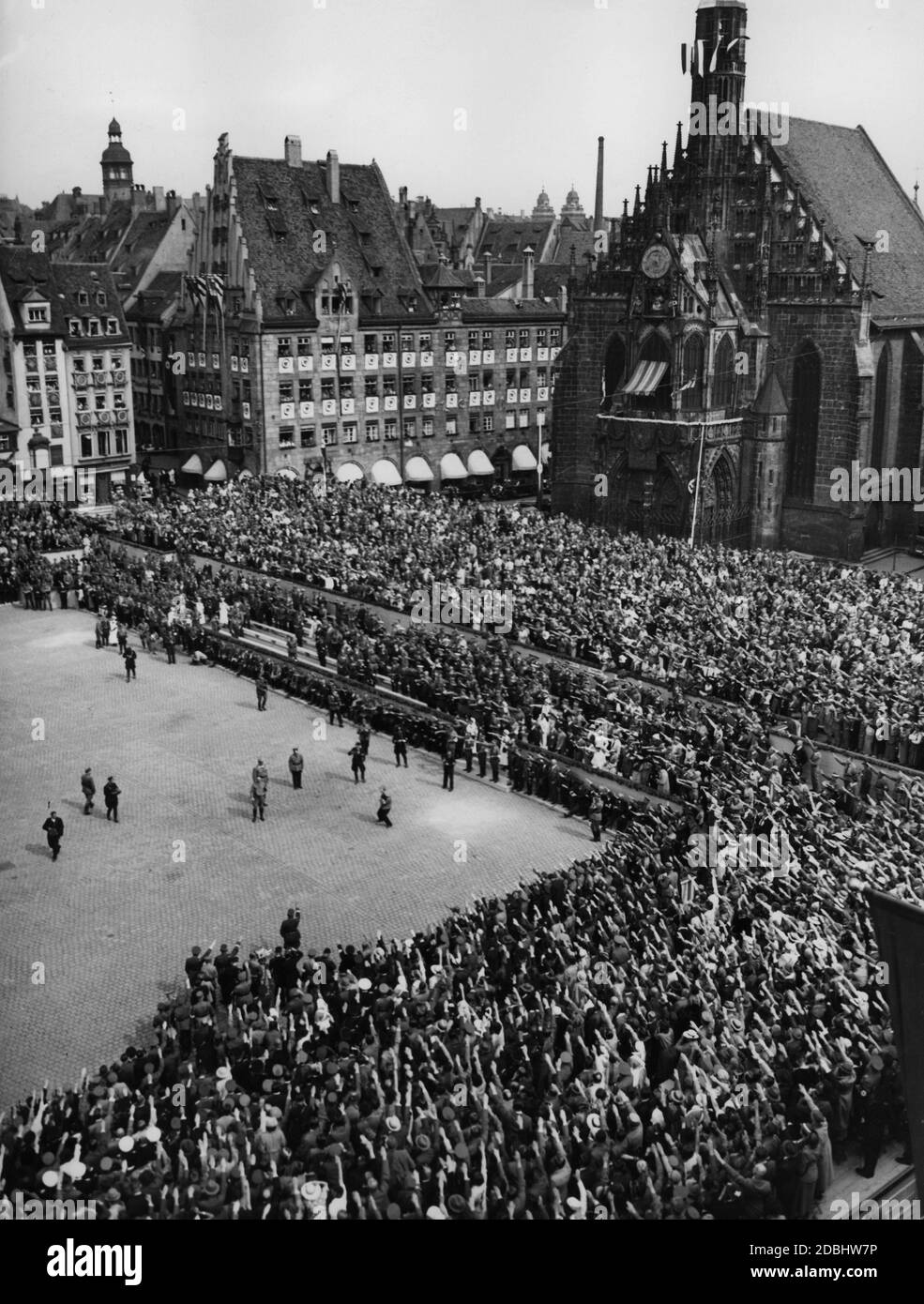 Blick auf die Tribünen am sogenannten Adolf-Hitler-Platz. In der Mitte des Platzes begrüßt Adolf Hitler Ehrengäste. Hinter ihm Wilhelm Brückner. Rechts befindet sich die Frauenkirche. Stockfoto