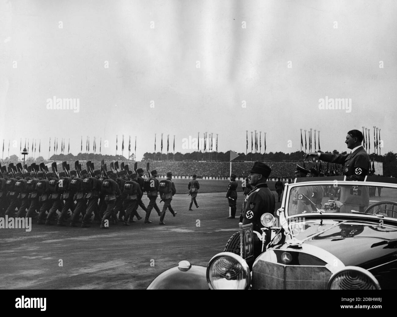 Adolf Hitler, der in einem Mercedes steht, inspiziert die Truppen des Reichsarbeitsdienstes auf dem Zeppelinfeld auf dem Reichsparteitagsgelände. Vor ihm stehen Konstantin Hierl und Wilhelm Frick. Stockfoto