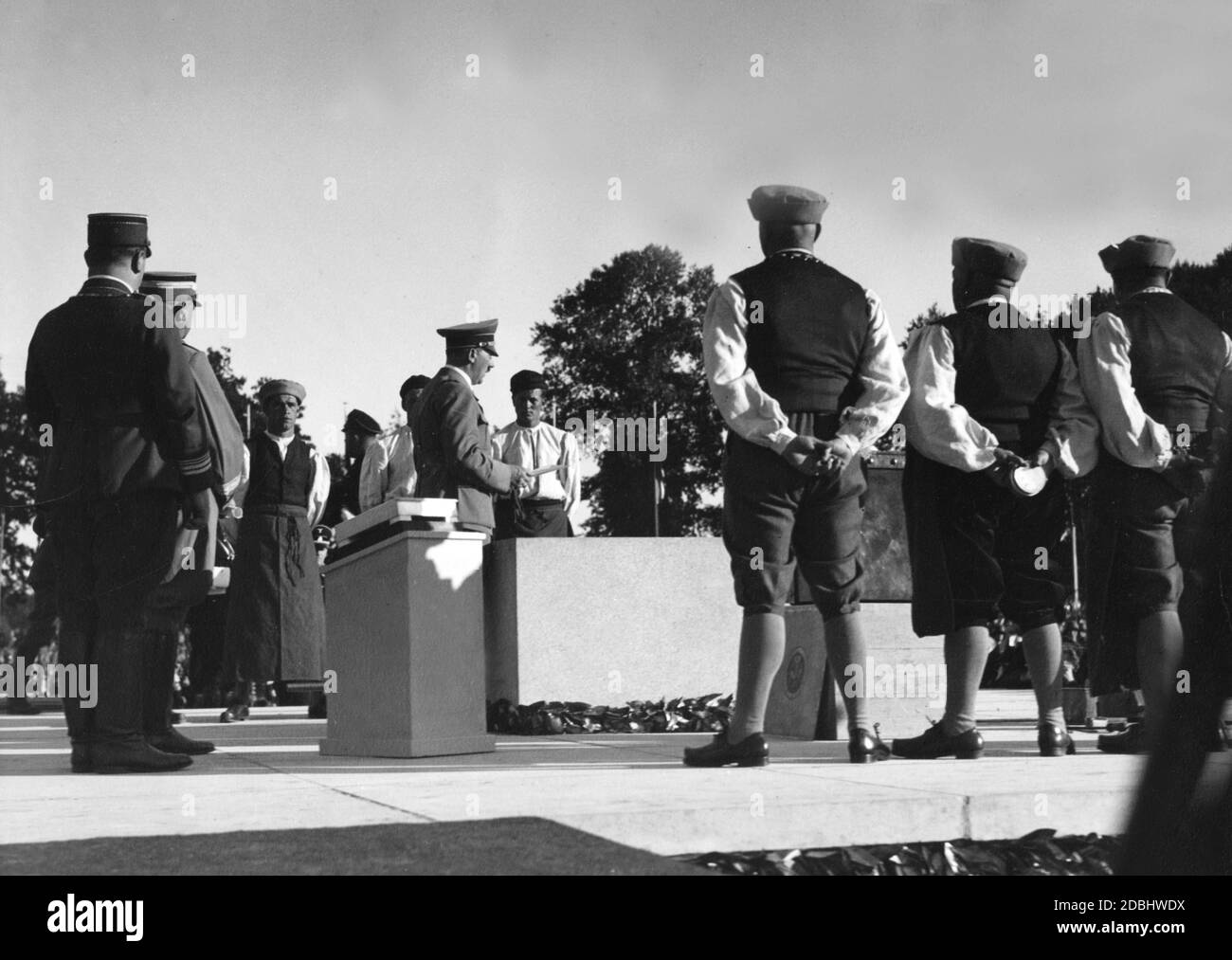 Adolf Hitler schlägt mit einem Hammer den Grundstein für die neue Kongresshalle auf dem Reichsparteitagsgelände in Nürnberg. Mit dem Rücken zum Betrachter, 3. Von rechts, Reichshandwerksmeister Wilhelm Georg Schmidt mit anderen Handwerkern in Tracht. Stockfoto