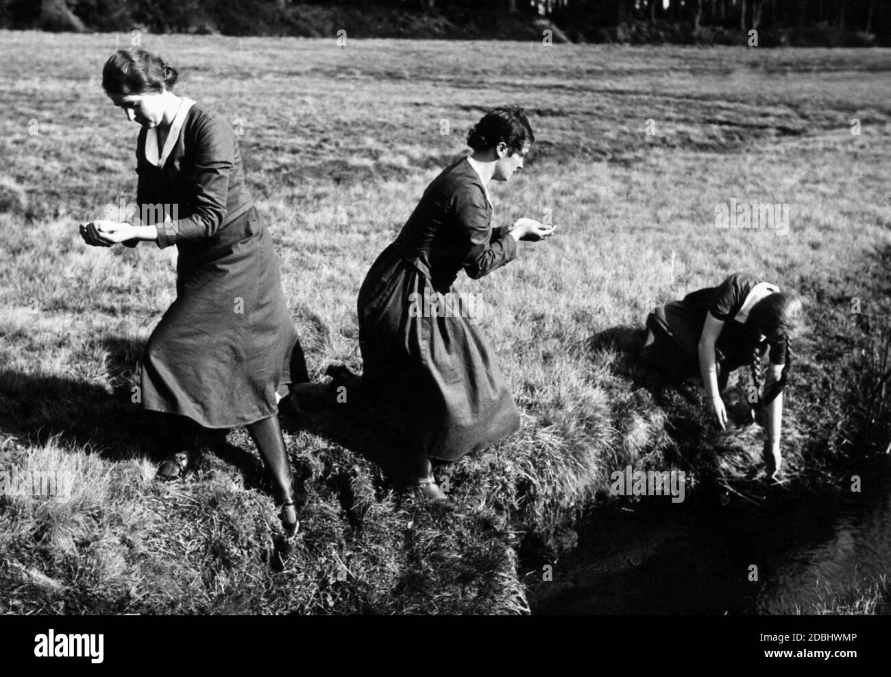 Bei einem germanischen Osterfest in der Nähe von Bad Fallingbostel in der Nacht des ersten Osterurlaubs sammeln Frauen stillschweigend Wasser aus einem Bach, das ihnen Schönheit und Gesundheit geben soll. Stockfoto