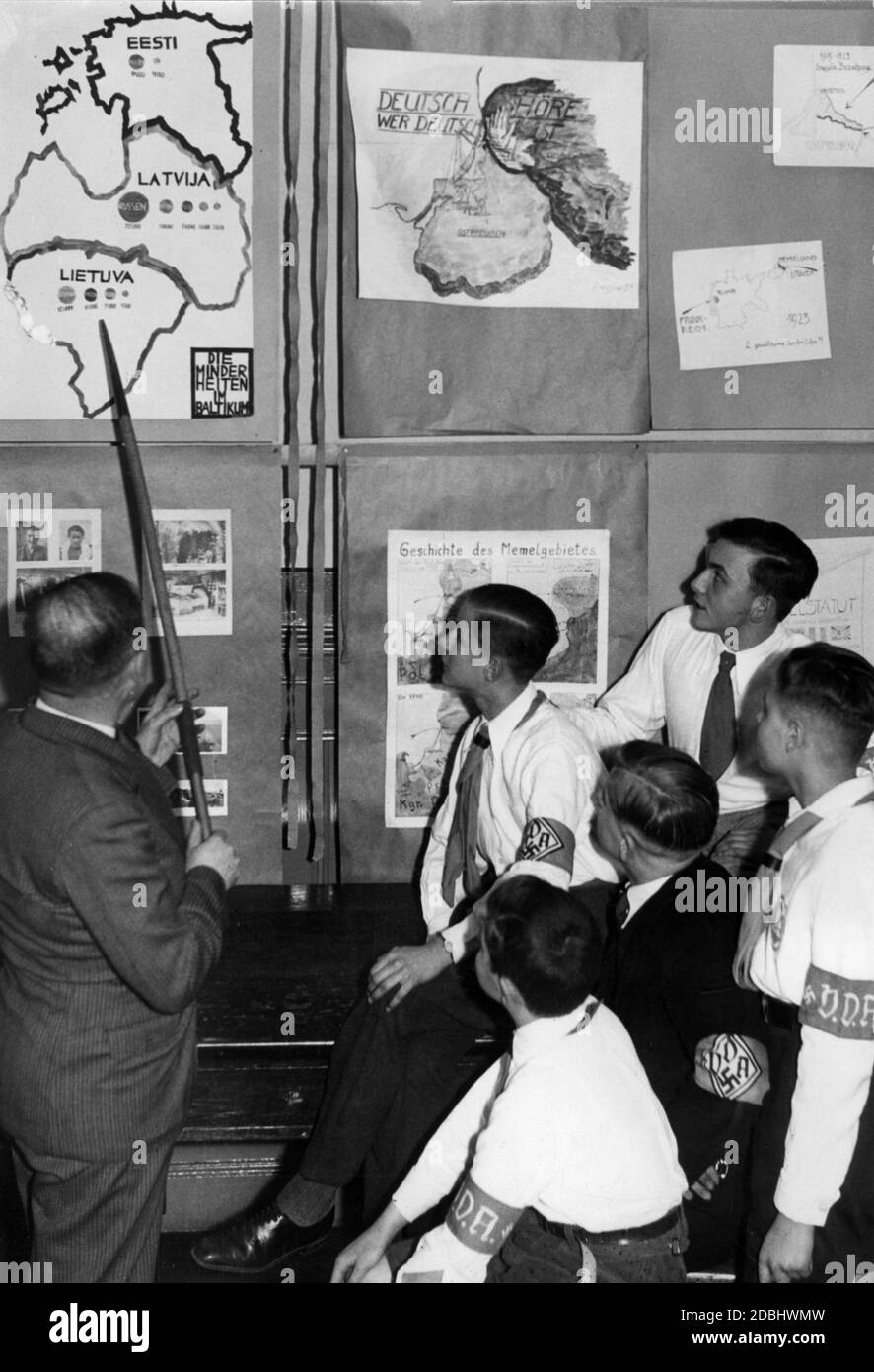 "Eine Lehrerin zeigt einer Gruppe von Schülern der VDA-Jugend eine Karte der Minderheiten in den baltischen Staaten, in der Ausstellung der Schüler des Berliner Koellnischen Gymnasiums mit dem Titel 'Deutsche Not im Memelland''. In der oberen Mitte befindet sich eine Karte von Ostpreußen mit der Aufschrift 'Deutsch hoere, wer deutsch ist'. Auf der rechten Seite ein Blatt über angebliche zwei gewalttätige Einbrüche aus Frankreich und Litauen. In der Mitte unten eine Darstellung der ''Geschichte der Memel-Gegend''.' Stockfoto