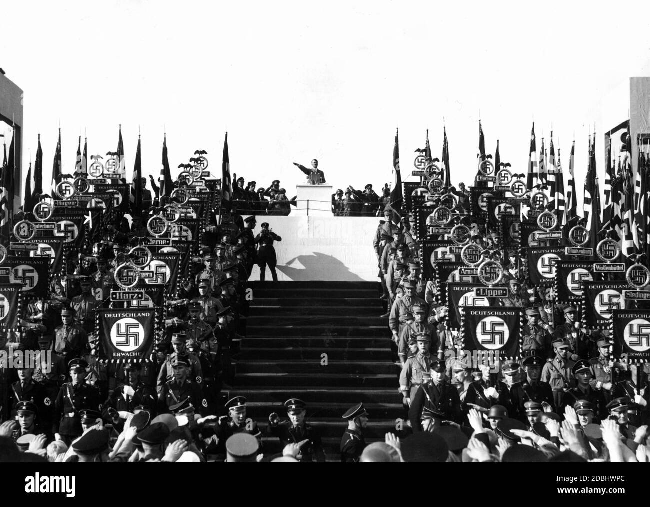 'Blick auf das Podium bei der Begrüßung Adolf Hitlers beim Reichserntedankfest ('' Reichserntedankfest'') auf dem Bueckeberg, links und rechts stehen SA-Standardträger.' Stockfoto