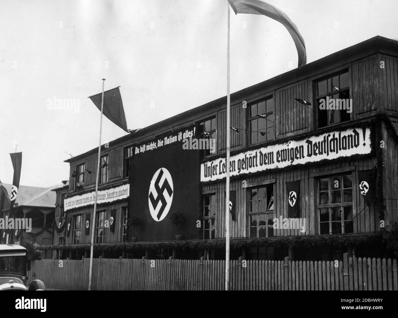 "In Essen hängen Banner an einem Arbeitsamt, das mit Hakenkreuzfahnen geschmückt ist. "Niemand wird unseren Glauben an die Zukunft Deutschlands stehlen", "Du bist nichts, die Nation ist alles" und "Unser Leben gehört dem ewigen Deutschland"." Stockfoto