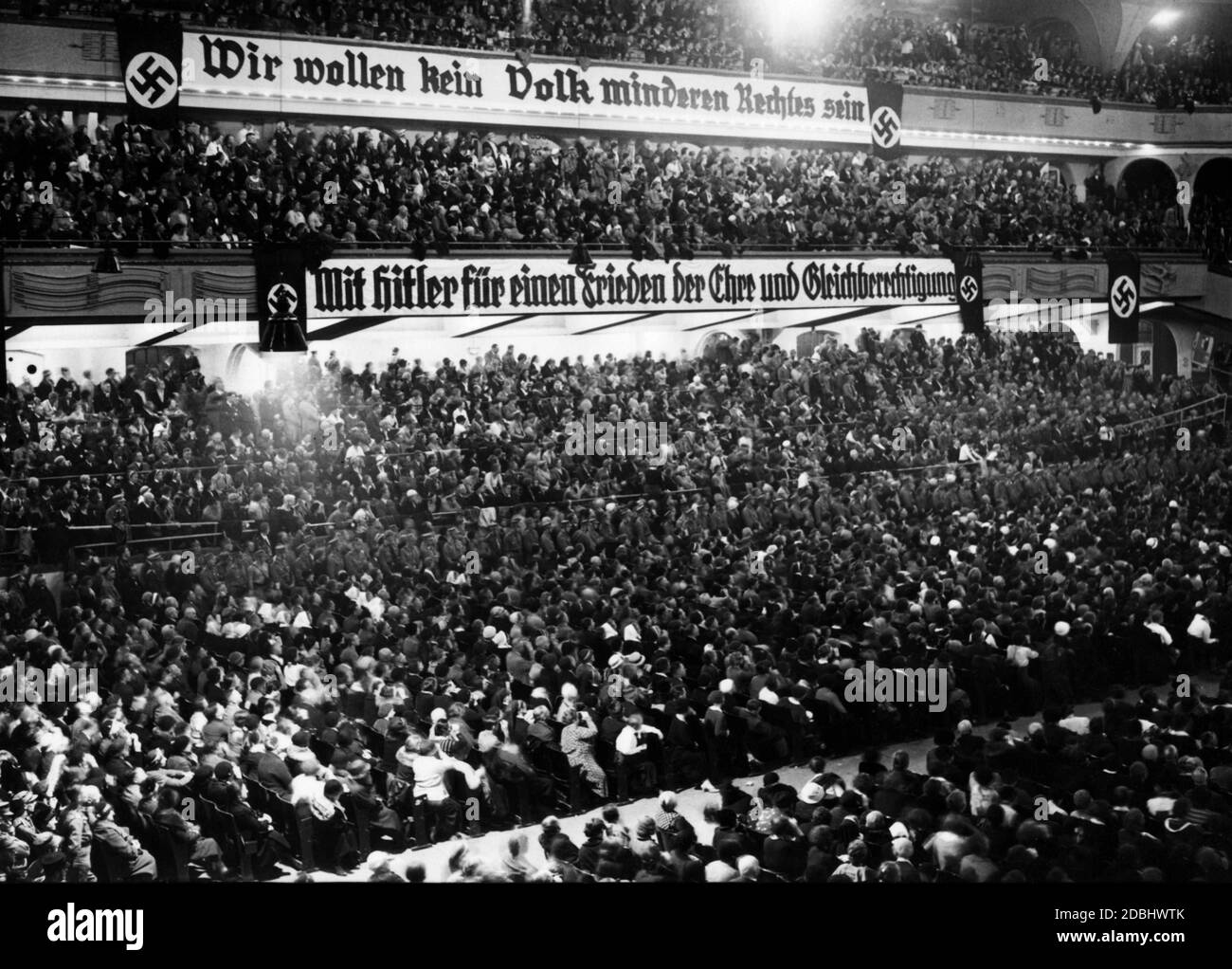 'Banner mit den Worten 'Wir wollen kein Volk minderen Rechtes sein'' über einem Banner mit der Aufschrift 'mit Hitler für einen Frieden der Ehre und Gleichberechtigung'' bei einer Wahlveranstaltung der SA.' Stockfoto