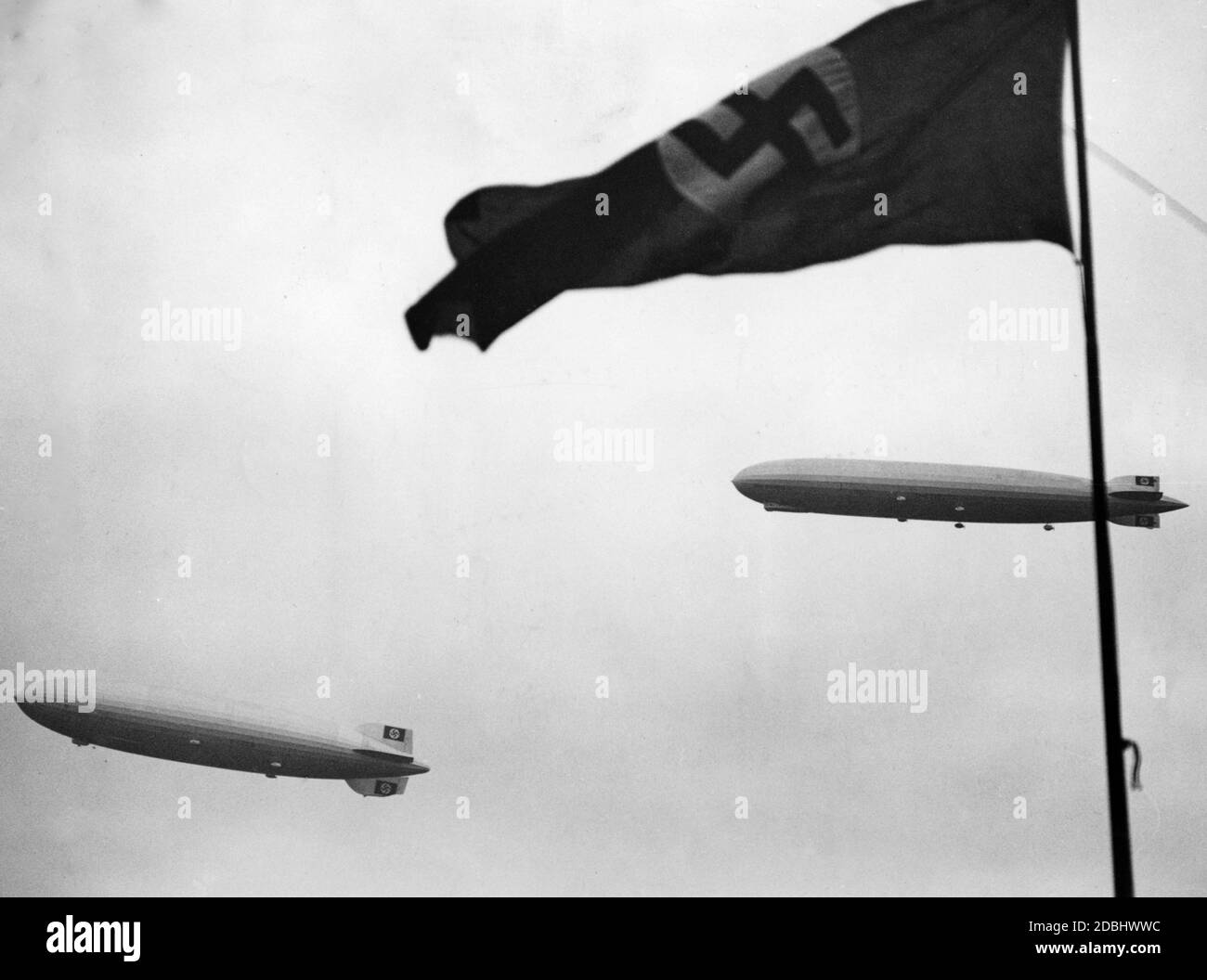'LZ 127 ''Graf Zeppelin'' und LZ 1929 ''Hindenburg'' am Himmel mit Hakenkreuzflagge.' Stockfoto