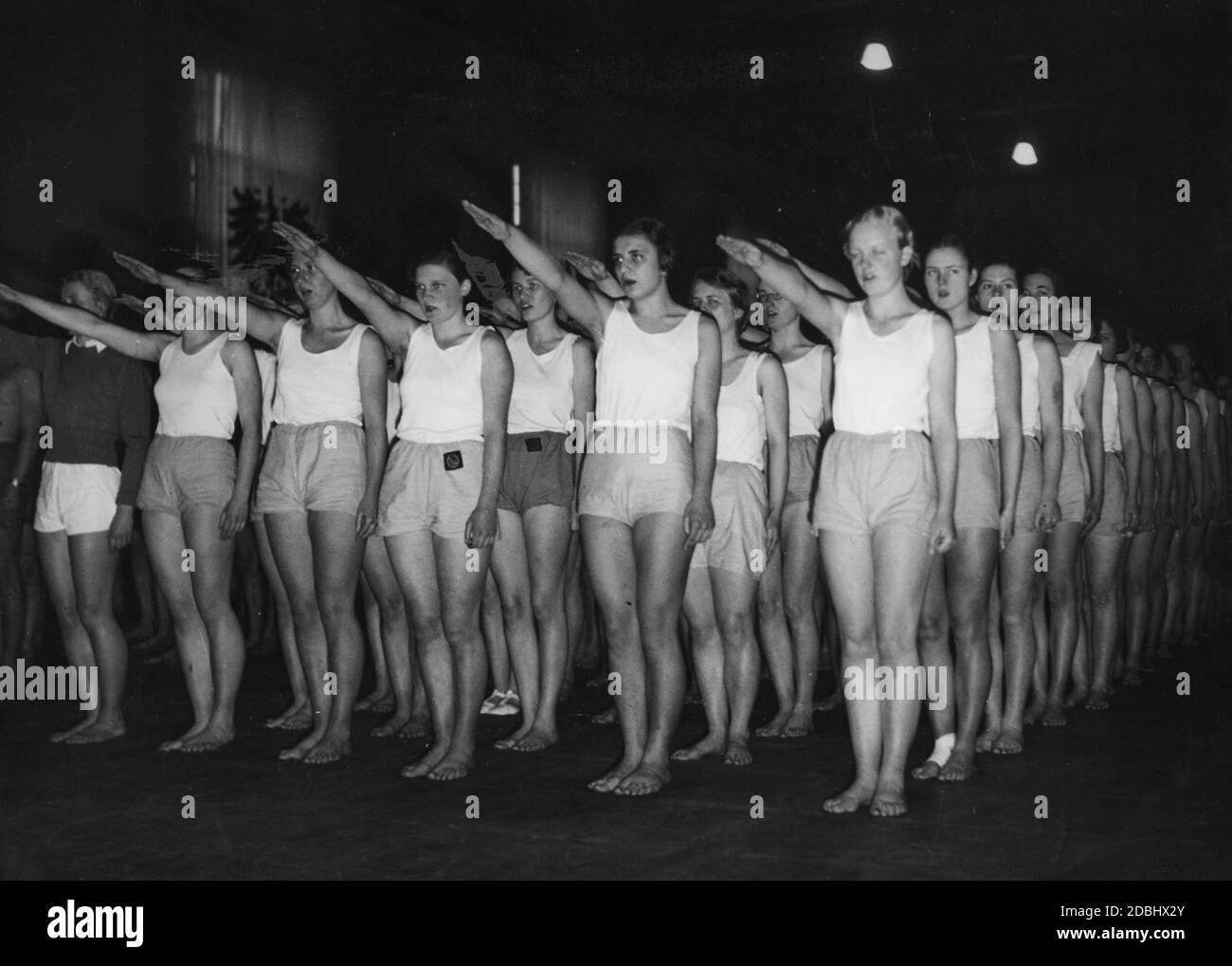 "In den Turnhallen des Hochschulinstituts für Leibesübungen feiert die Berliner Studentenschaft am 13. Februar den Tag der Leibesübungen. Hier führt eine Gruppe Studentinnen den Nazi-Gruß durch. Undatierte Aufnahme.' Stockfoto