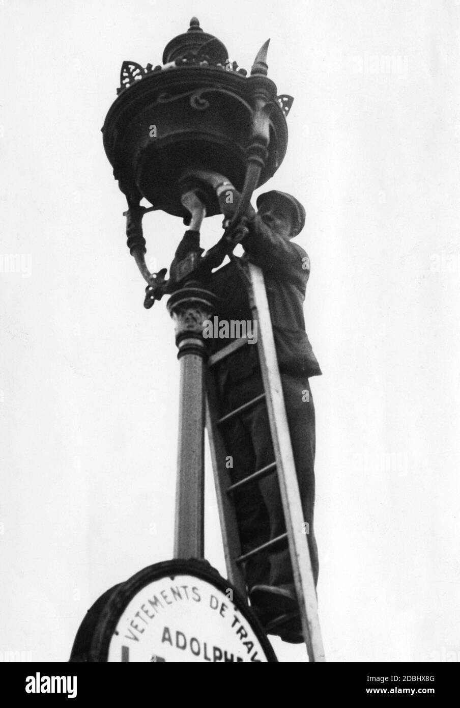 Ersatz der hellen Glühbirnen in den Straßenlampen als Vorbereitung für Blackout-Maßnahmen in Paris im Jahr 1939. Stockfoto