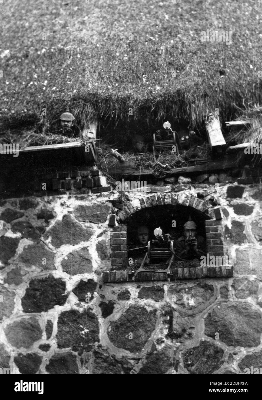 Deutsche Soldaten mit Maschinengewehren im Erdgeschoss und Dachboden einer Scheune in einem Gebäude an der Westfront während des Ersten Weltkriegs. Stockfoto