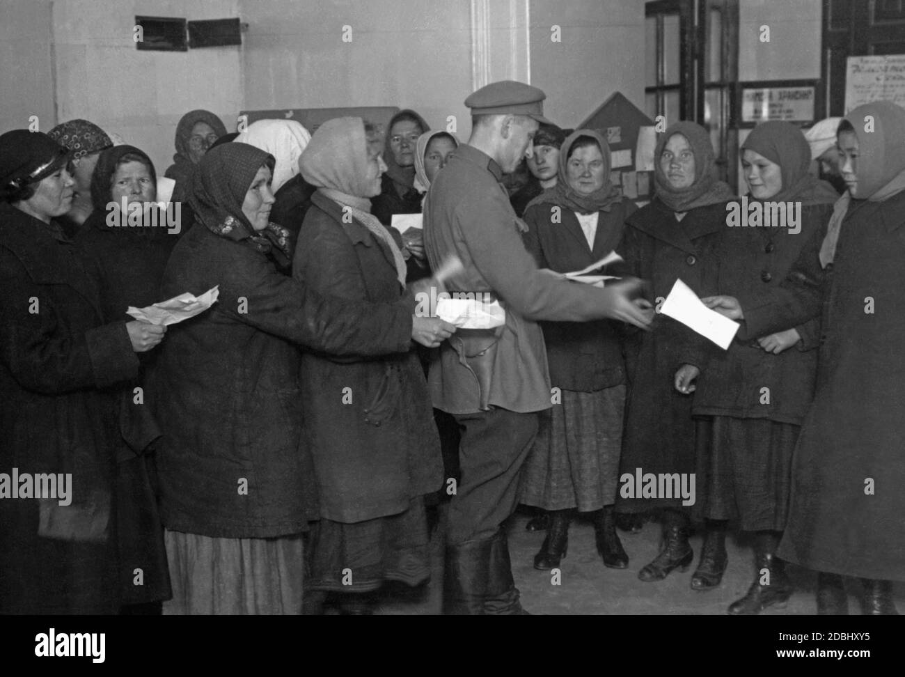 Ein Beamter überprüft die Arbeitsbescheinigungen von Frauen in einer Moskauer Fabrik. Stockfoto