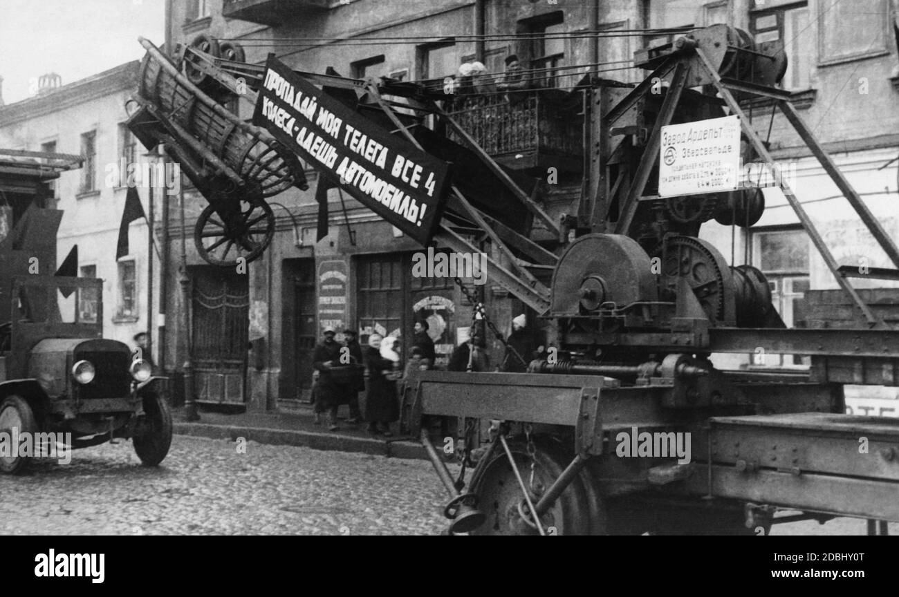 'Banner auf einer Propagandaparade mit der Aufschrift: 'Weg mit den Bauernwagen, gib uns Autos''.' Stockfoto