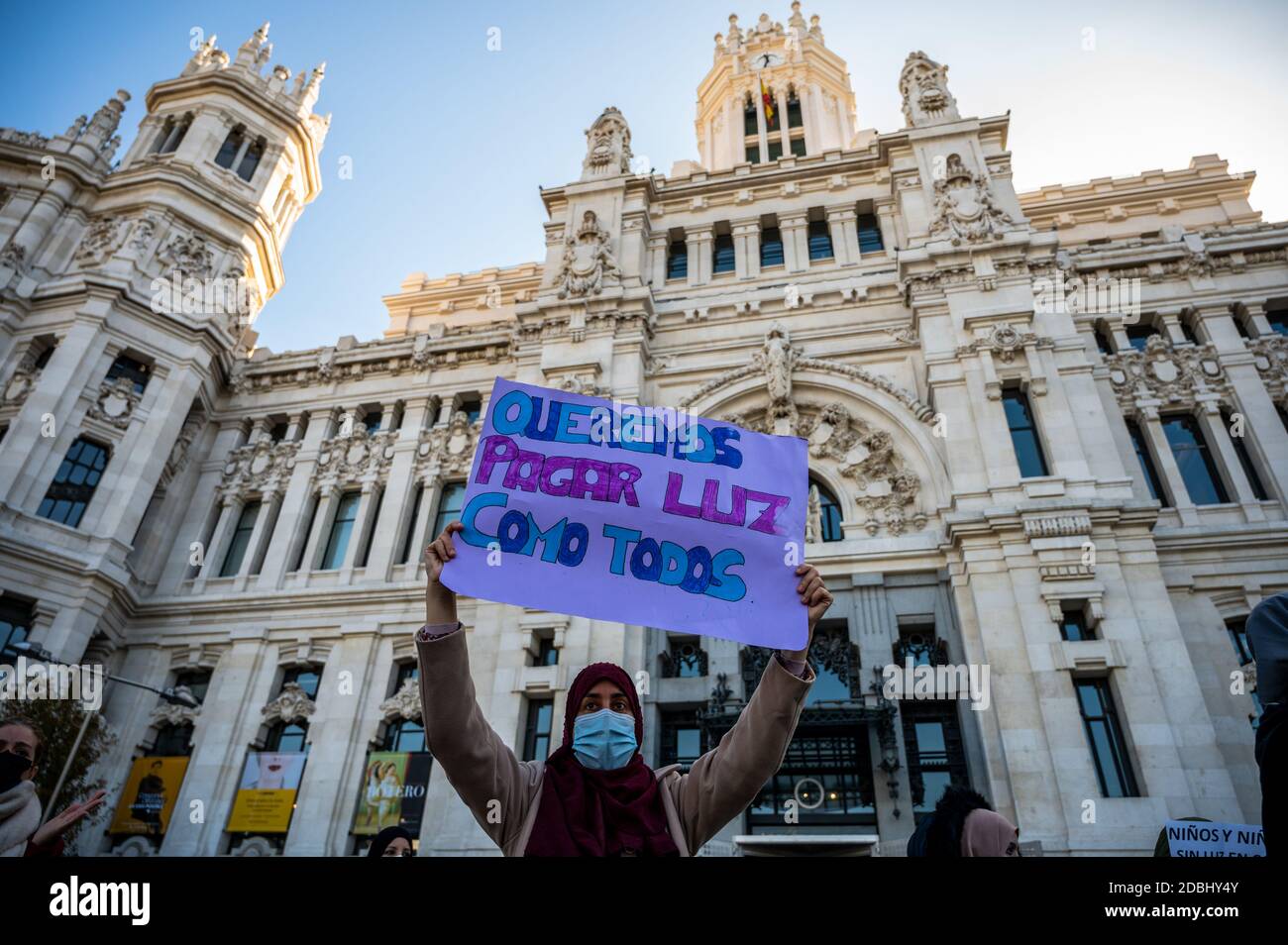 Madrid, Spanien. November 2020. Eine Frau, die ein Plakat mit der Aufschrift trägt: "Wir wollen wie alle anderen für Strom bezahlen". Nachbarn der Cañada Real protestieren vor dem Stadtrat von Madrid, um eine Lösung für die Stromausfälle in der Kleinstadt zu fordern. Die Nationale Polizei hat mehrere Razzien gegen Marihuanaplantagen in La Cañada durchgeführt und mehr als tausend Pflanzen beschlagnahmt. Diese Strukturen könnten hinter illegalen Anschlüssen stecken, die von dem Elektrounternehmen entdeckt wurden, das das Netz überlädt. Quelle: Marcos del Mazo/Alamy Live News Stockfoto