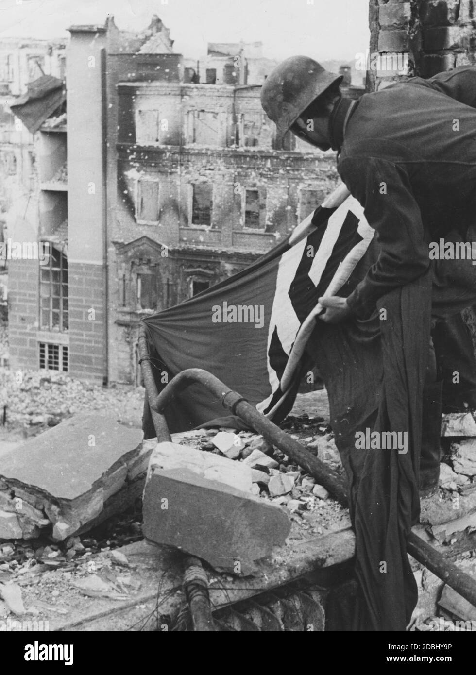 Ein deutscher Soldat legt eine Hakenkreuzflagge als Kennzeichen für Flugzeuge aus. Stockfoto