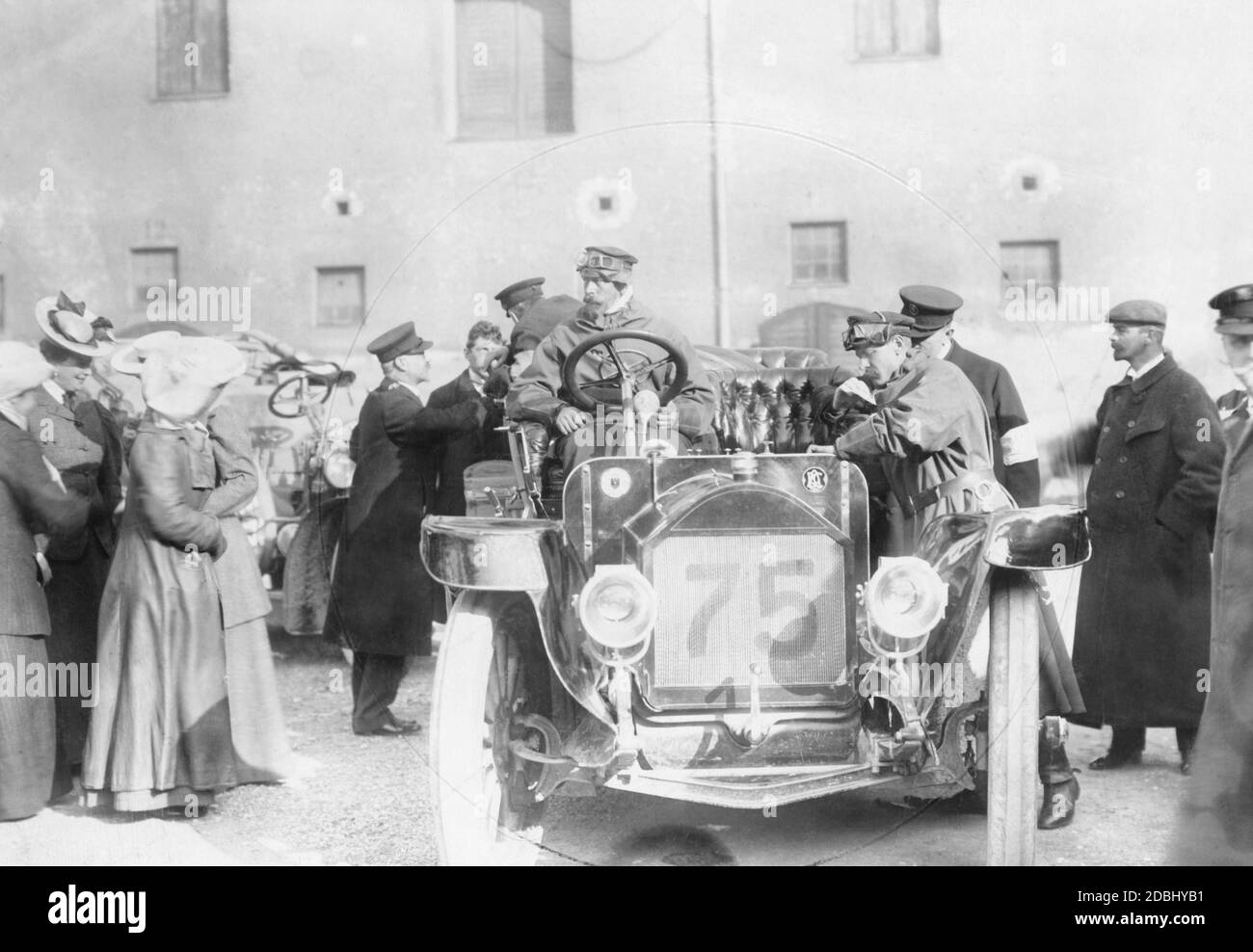 Prinz Heinrich von Preußen (Mitte links) sitzt am Steuer seines Autos (ein 40-PS-Benz mit der Nummer 75) während der Hercomer-Fahrt von 1906, die zwischen dem 6. Und 12. Juni stattfand. Hier macht er Halt in München. Links von der Motorhaube ist das Logo des Kaiserlichen Automobil-Clubs zu sehen. Stockfoto