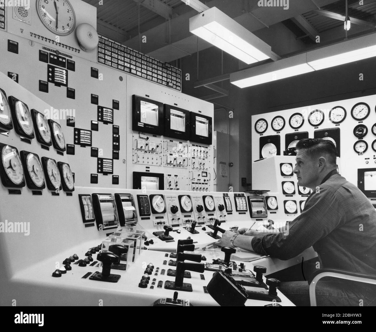 Steuerkonsole im Kernkraftwerk Humbolt Bay der Pacific Gas and Electric Company, das von einem von der Atomenergiekommission zugelassenen Betreiber besetzt ist. Konsole enthält alle Steuergeräte, die für den normalen Betrieb von Reaktor und Turbinengenerator benötigt werden, sowie Notfallsteuerungen, die eine vollständige Abschaltung der Anlage in drei Sekunden ermöglichen, Humbolt Bay, CA, 1964. (Foto von Pacific Gas and Electric Company/United States Information Agency/RBM Vintage Images) Stockfoto
