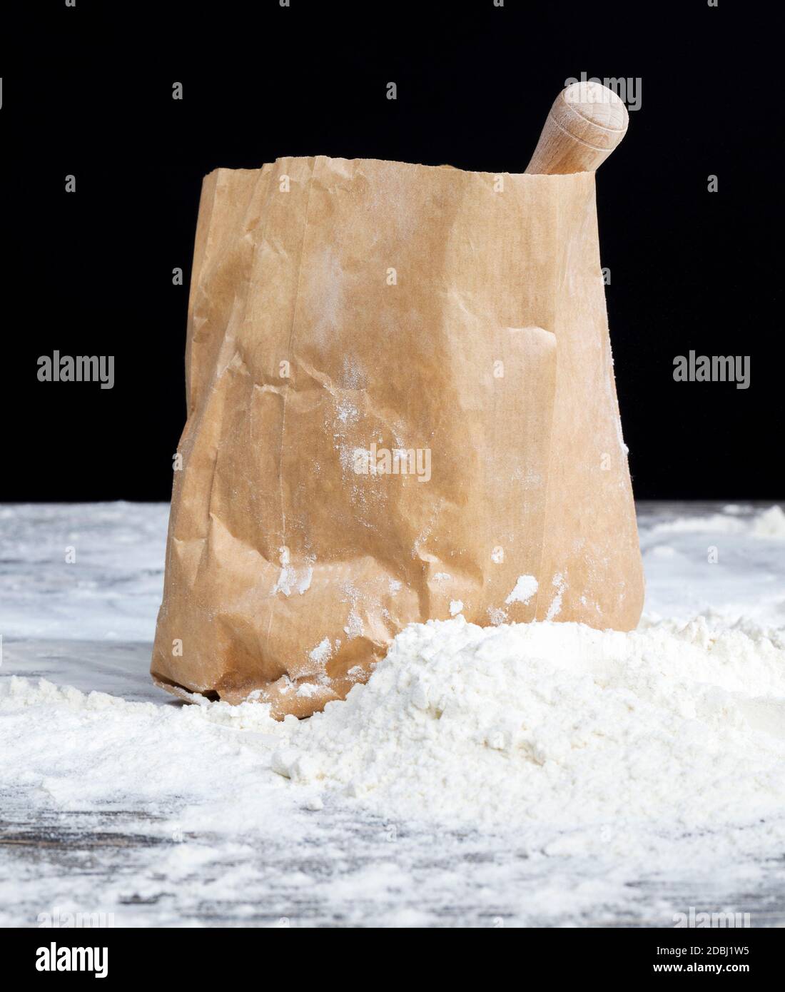 Die Zutaten für die Herstellung von Pasta aus Hartweizen, Weizenmehl in einem Papierbeutel mit einem Holzlöffel Stockfoto