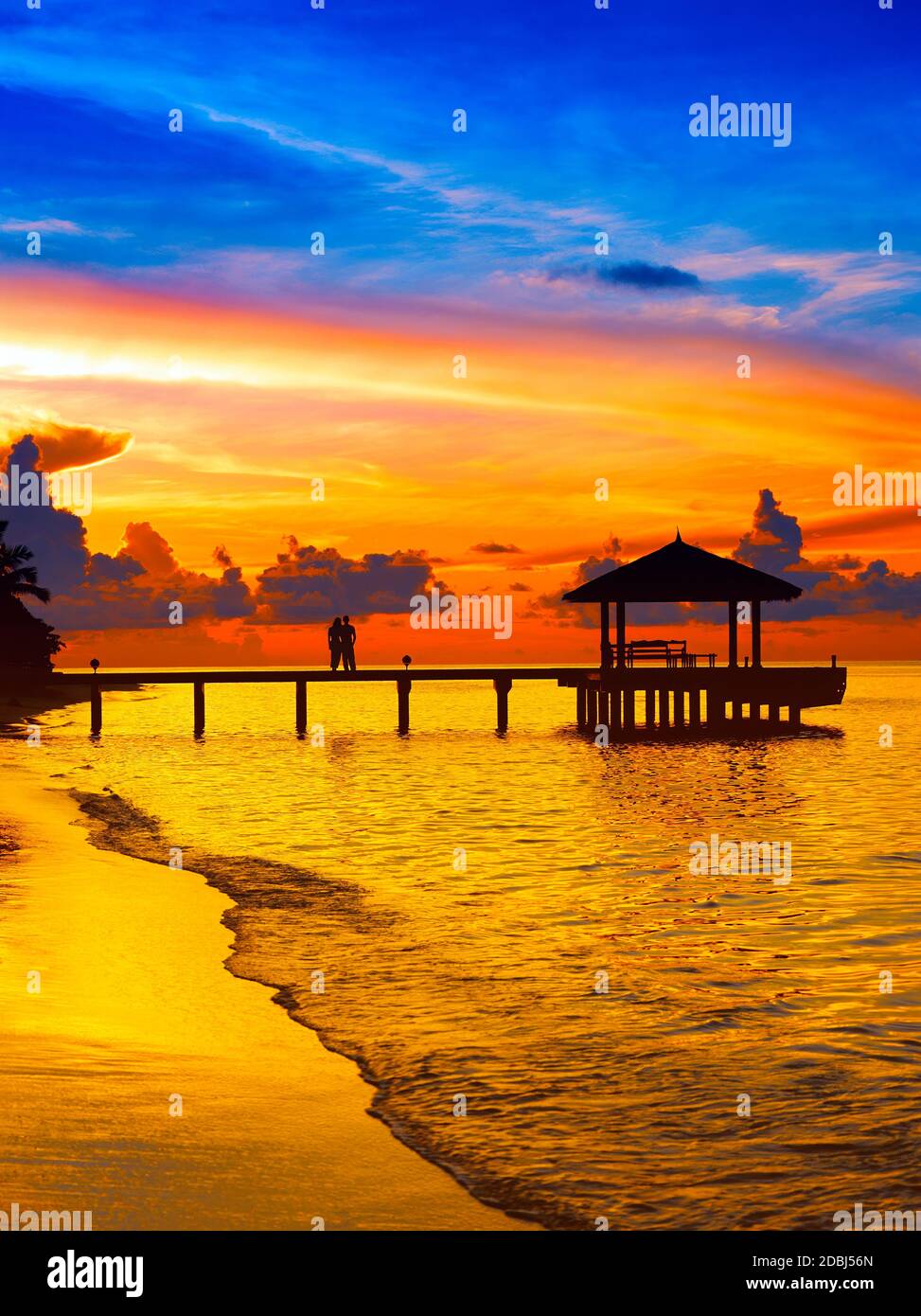 Pärchen auf dem Steg mit Blick auf den Sonnenuntergang, die Malediven, den Indischen Ozean, Asien Stockfoto