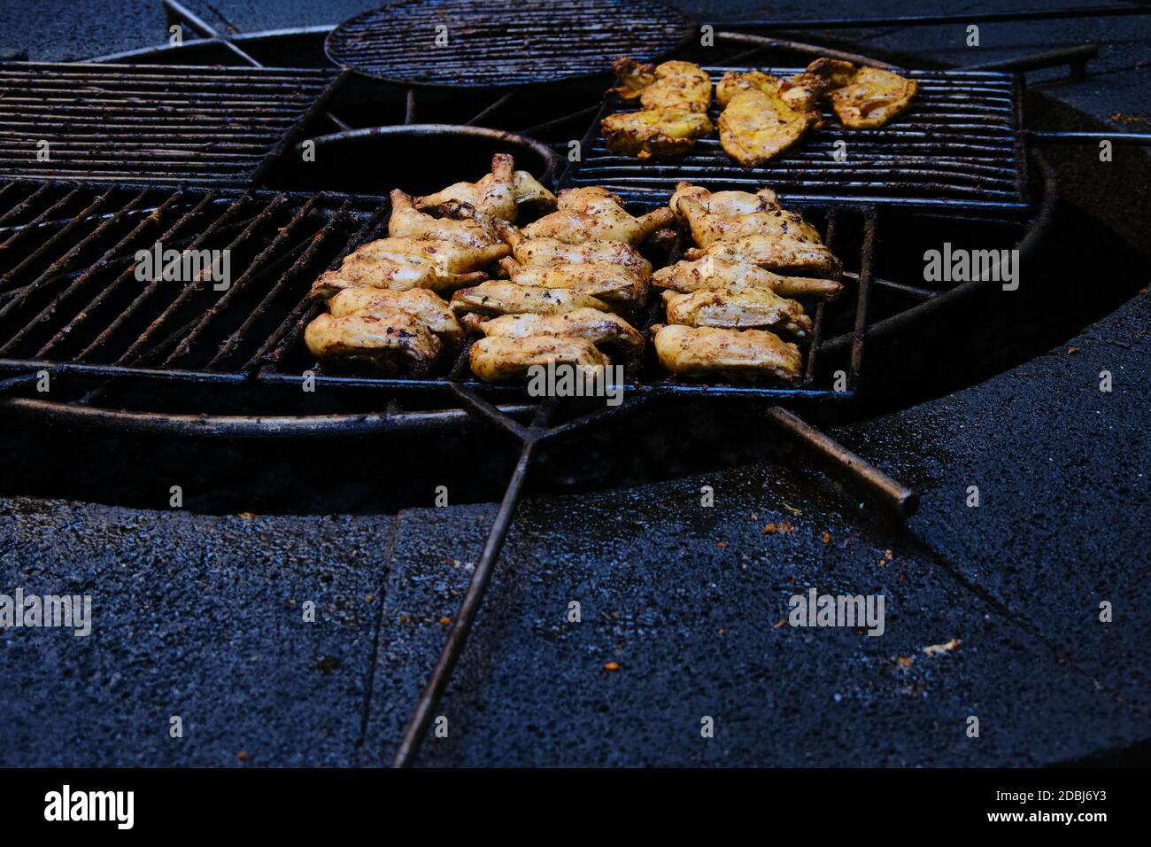 Hühnerstücke werden auf einem Grill über dem Vulkangestein gebacken und gebraten. Es ist in Timanfaya Nationalpark, Lanzarote, Kanarische Inseln, Spanien. Stockfoto