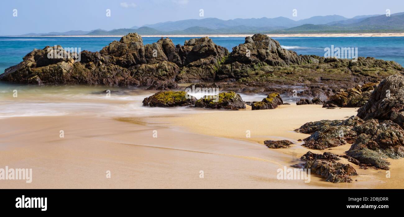 Der schöne nasse Sand und Felsen mit Algen bedeckt. Playa Mayto in Jalisco, Mexiko. Stockfoto