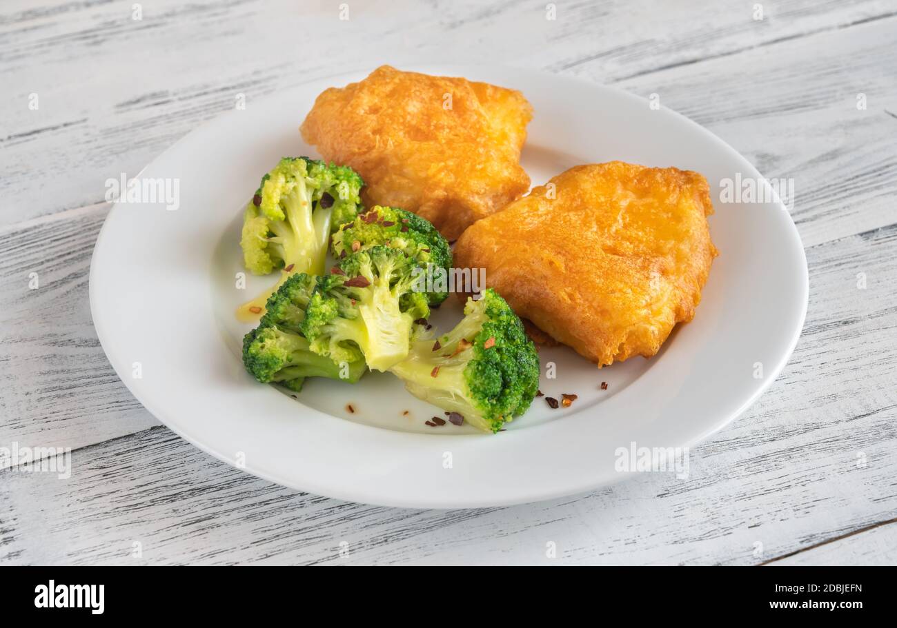 Portion zerbroschenen Fisch mit gedämpftem Brokkoli Stockfoto