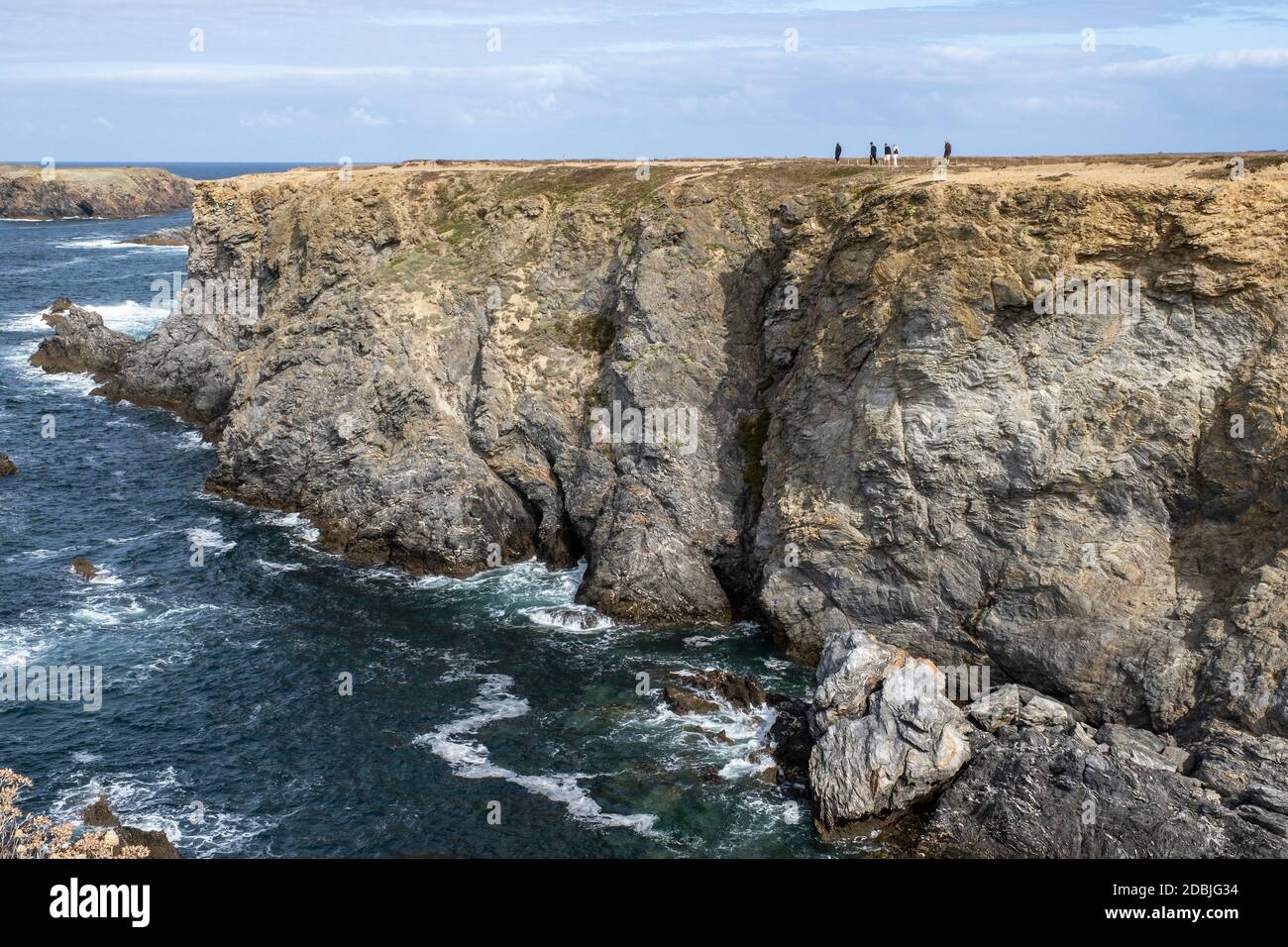 Menschen, die entlang der Klippen von Les Aiguilles de Port Coton, auf der Insel Belle Ile, Bretagne, Frankreich, wandern Stockfoto