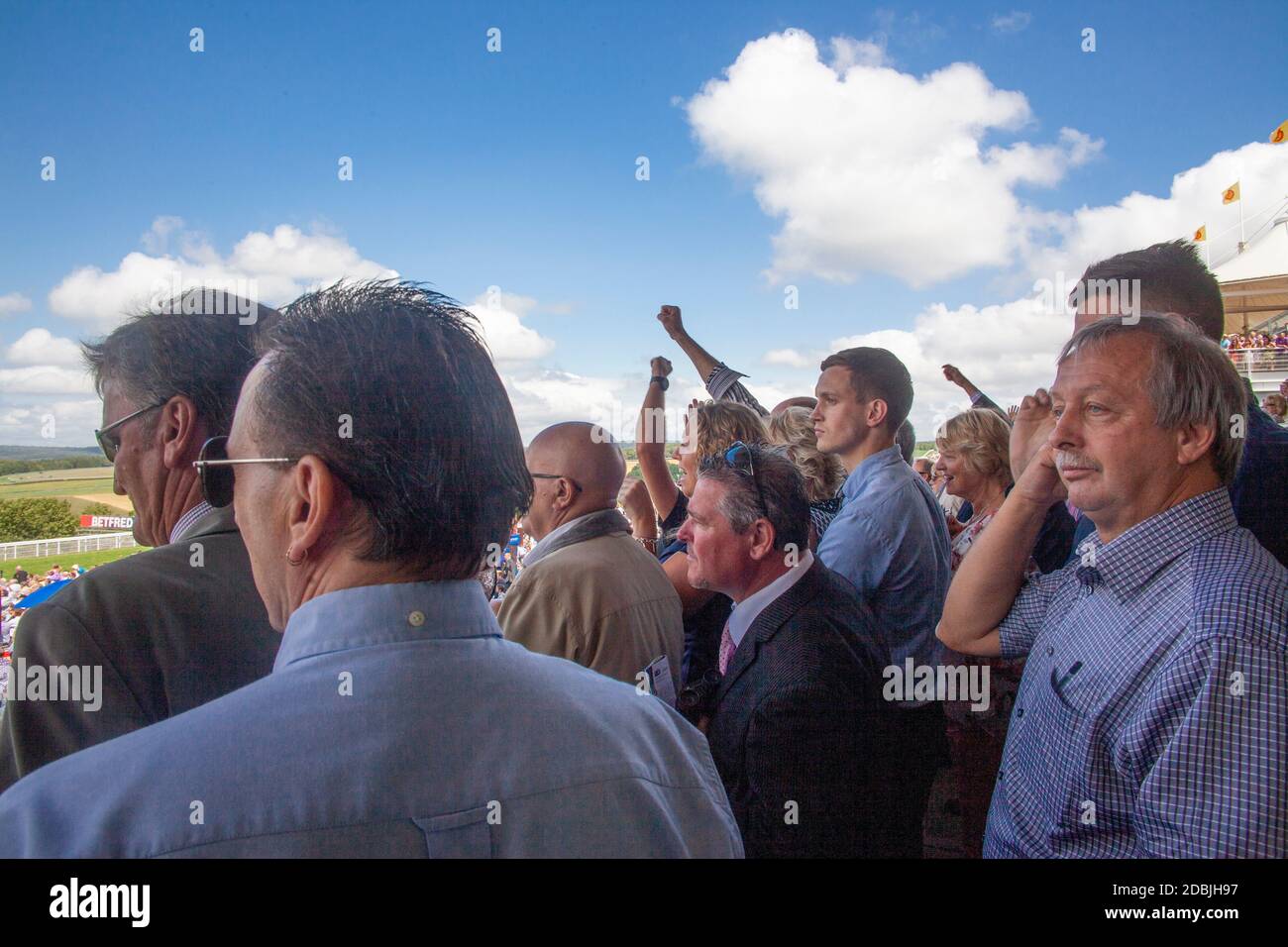 Rennfahrer beobachten das glorreiche Goodwood-Renntreffen auf der Goodwood-Rennbahn in der Nähe von Chichester, West Sussex; das Qatar Goodwood Festival Stockfoto