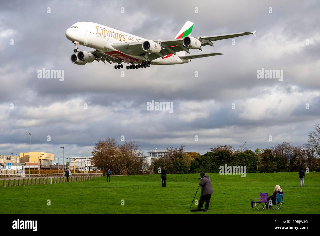 Flugzeugbeobachter, Luftfahrtbegeisterte, im grünen Space Park in der Nähe der Myrtle Avenue und beobachten ein Jet-Flugzeug, das am London Heathrow Airport in Großbritannien landet Stockfoto