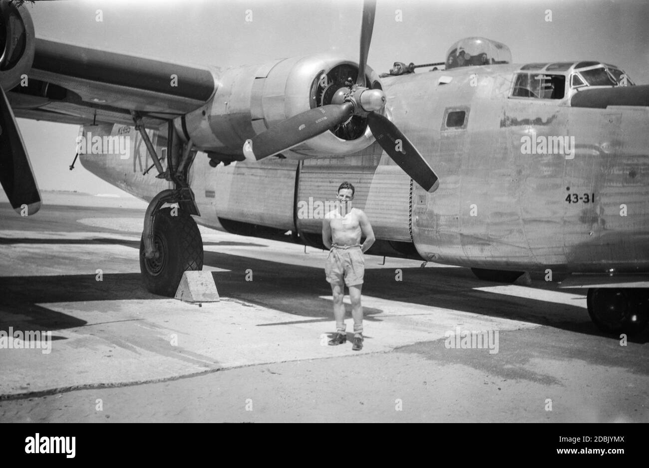 Ein britischer Flieger der Royal Air Force, der vor einem Transportflugzeug der Royal Air Force Consolidated Liberator bei der RAF El-Adem in Libyen 1945 steht. Jetzt bekannt als Gamal Abdel Nasser Airbase. Stockfoto