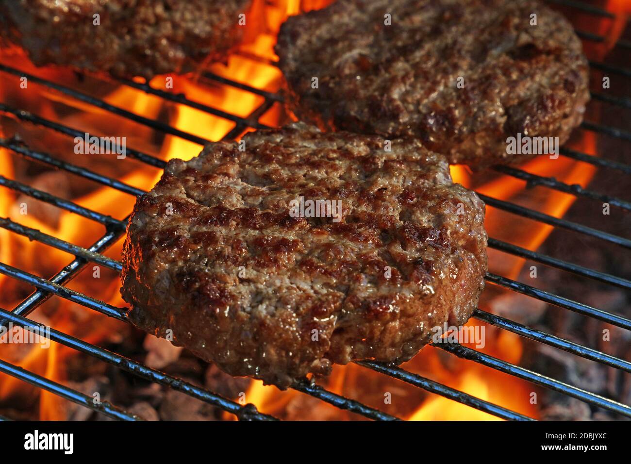 In der Nähe von Rind- oder Schweinefleisch Fleisch Grill Burger für Hamburger vorbereitet auf bbq Feuer Flamme Grill gegrillt, hohe Betrachtungswinkel Stockfoto