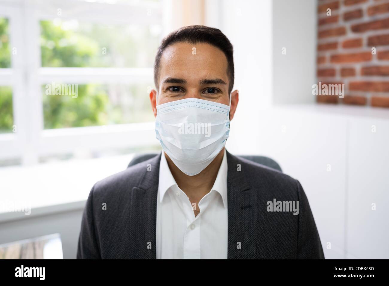 Männliche Rezeptionistin In Arzt Gesichtsmaske Stockfoto