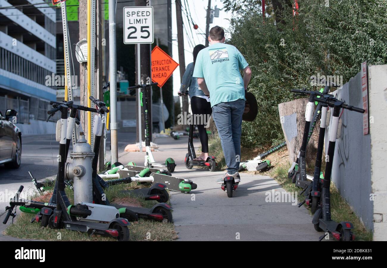 Scooters Würgen die Ecken von East Cesar Chavez und Red River Street an einem Sonntagmorgen in der Innenstadt von Austin, TX. Die beliebte Art, Austin's Stadtkern zu erkunden, hat eine Reihe von urbane Gefahren hervorgebracht, nachdem viele Besucher sie nach einer Partynacht in den Unterhaltungsvierteln Rainey und Sixth Street auf Gehwege werfen. Stockfoto