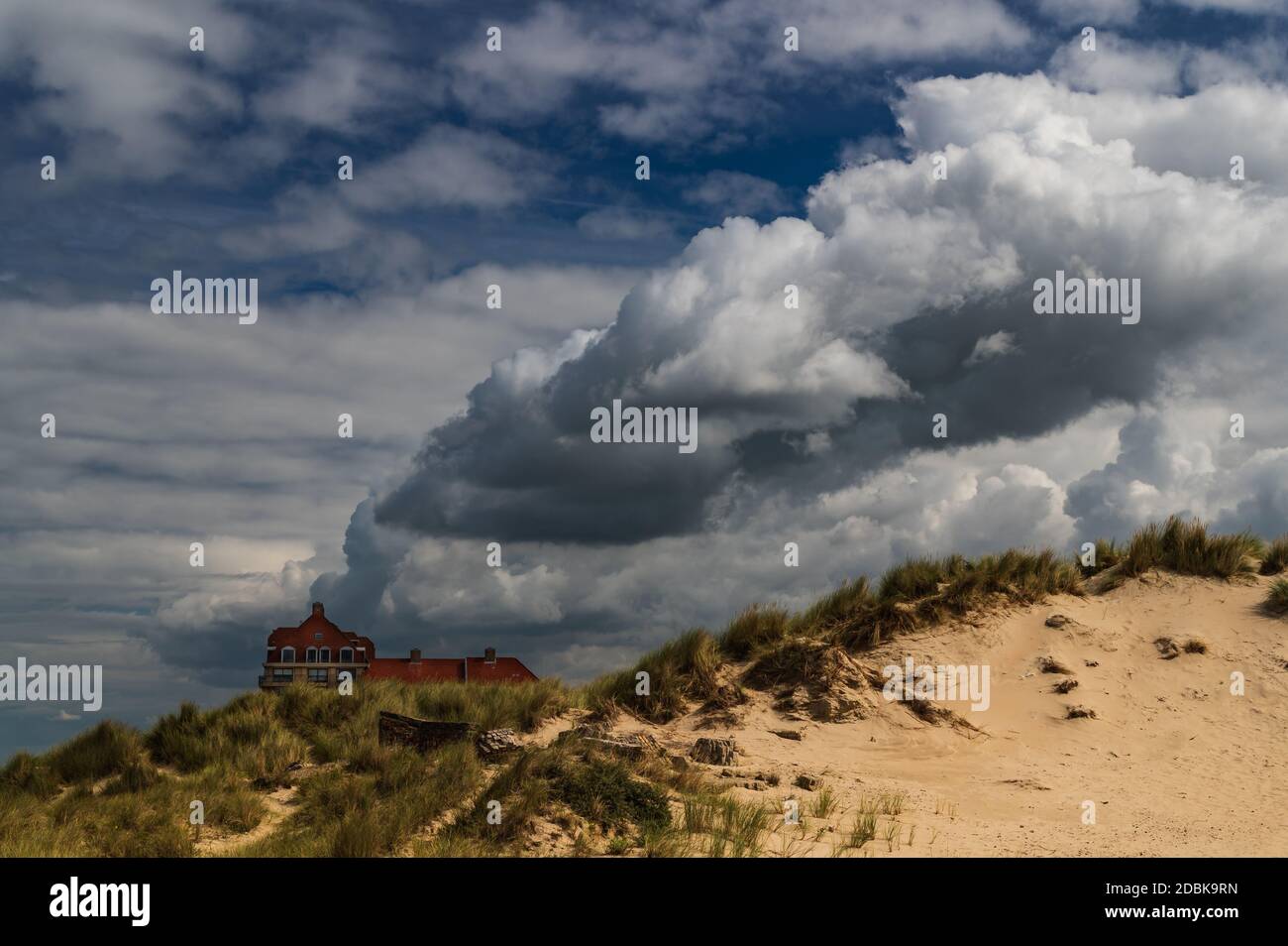 Von den zerstörten Dünen aus gesehen scheint eine riesige Wolke aus einem Gebäude zu kommen. Stockfoto