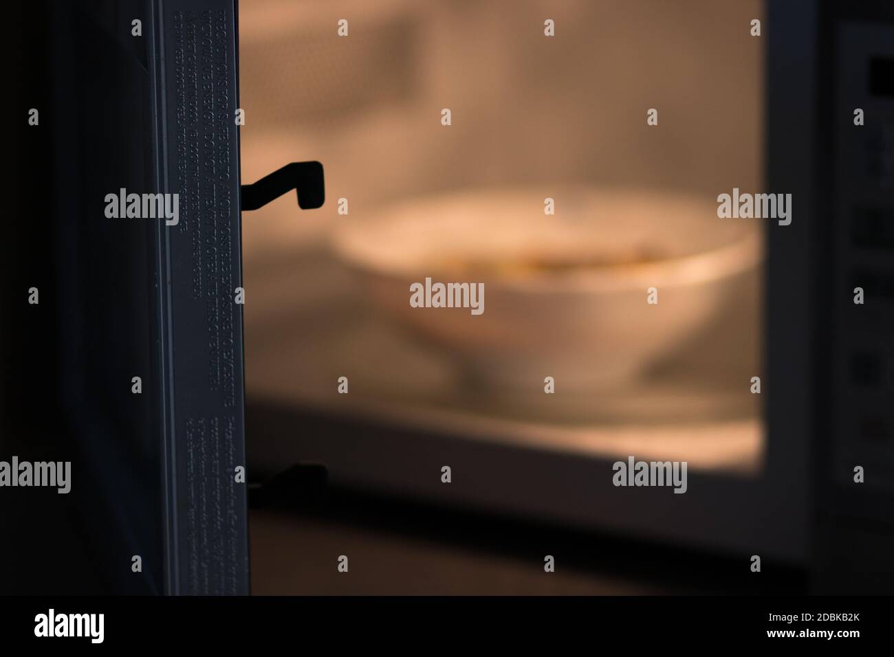Eine Schüssel Suppe wird darin erhitzt werden Eine Mikrowelle Stockfoto