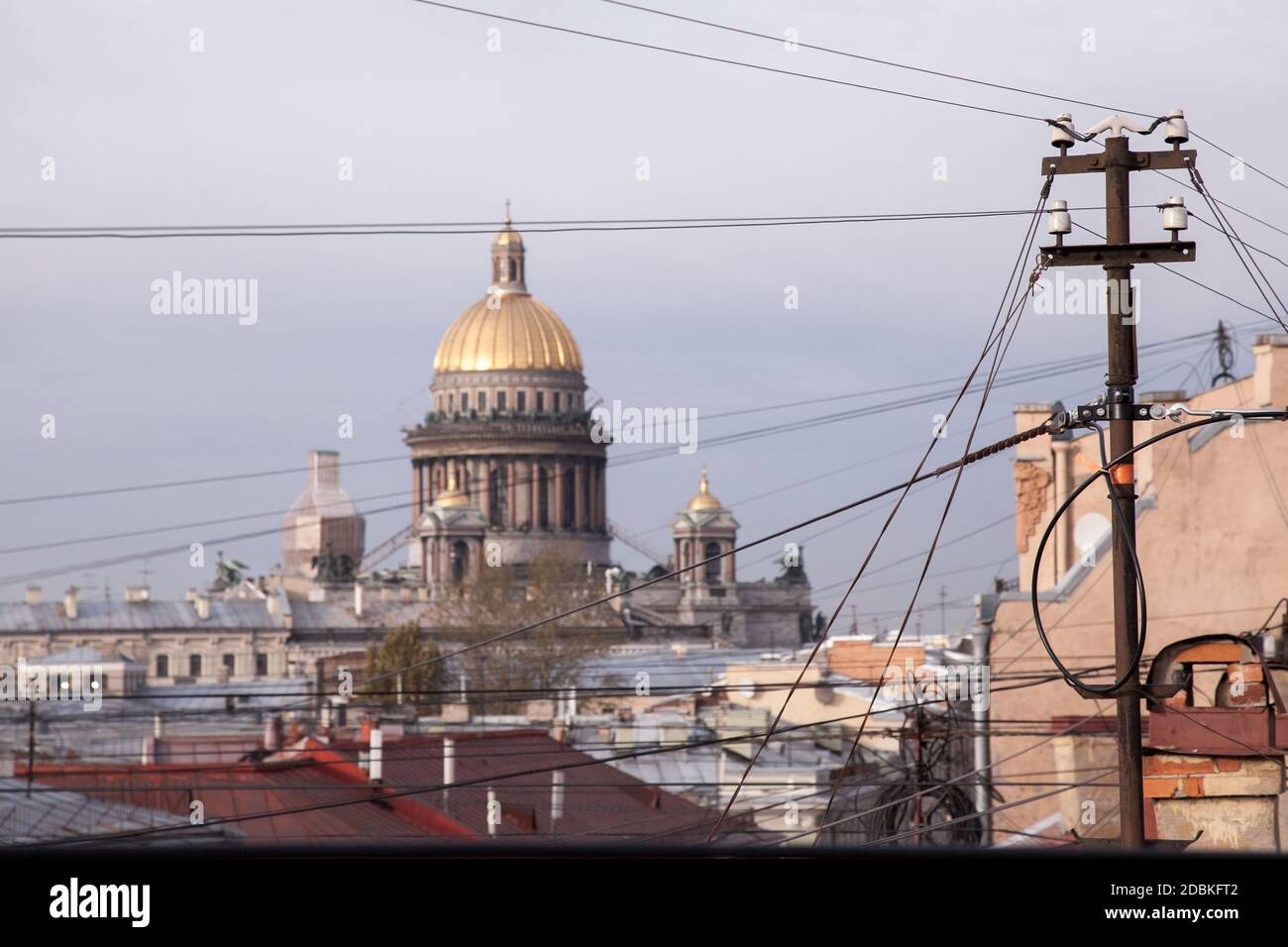 Drähte und Dächer von St. Petersburg, Russland. St. Isaac Kathedrale Kuppel ist auf einem Hintergrund Stockfoto
