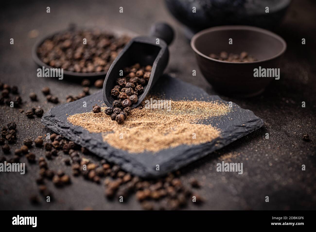 Kochzutaten Konzept mit ganzen und gefrästen schwarzen Pfefferkörner Stockfoto