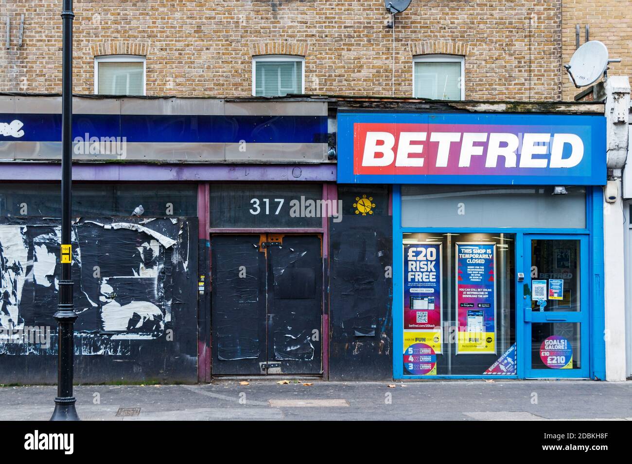 Betfred Wettgeschäft, geschlossen während der zweiten Coronavirus Pandemie Lockdown, neben einem leeren und verschlossenen Shop in Kentish Town, London, UK Stockfoto
