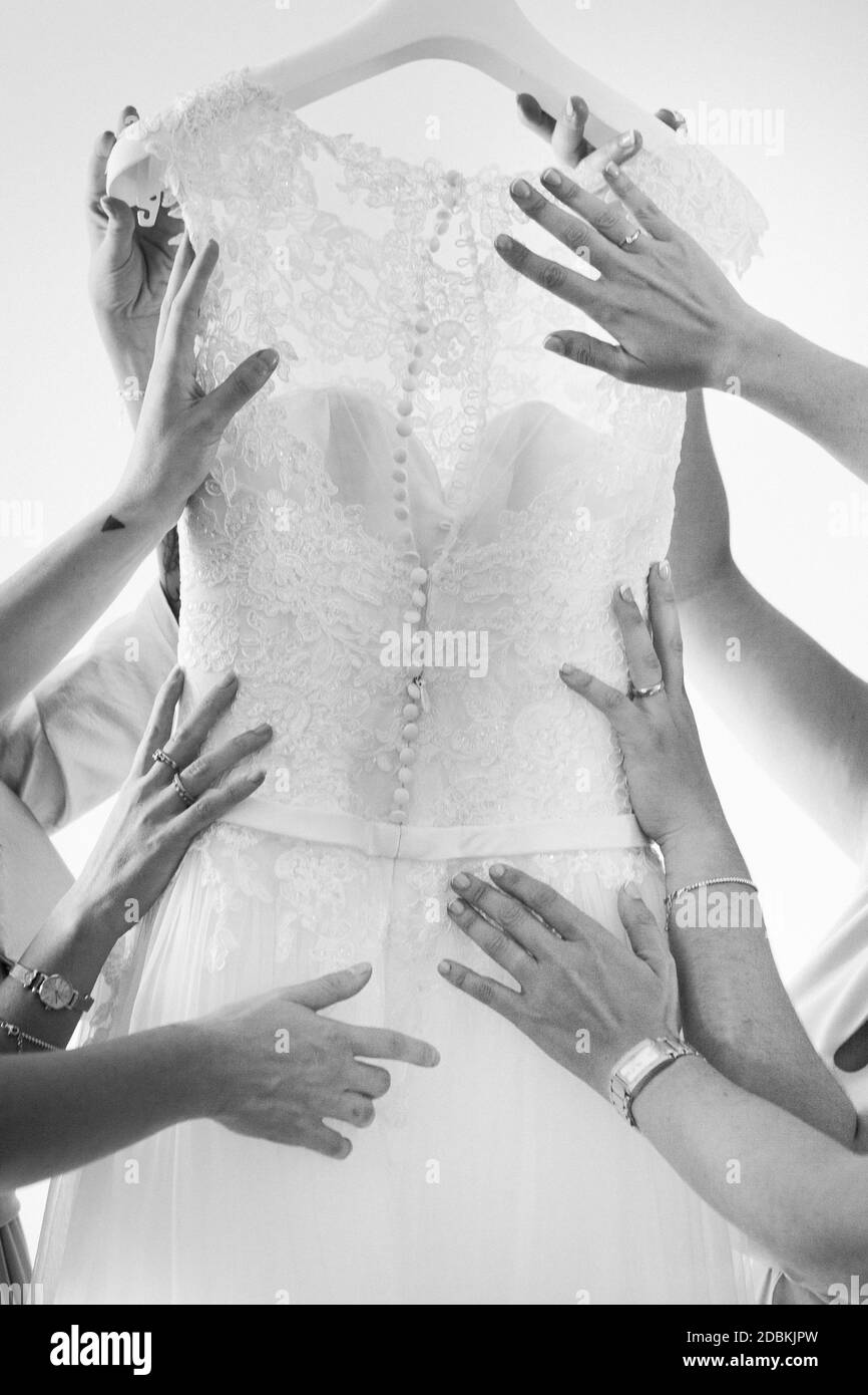 Hände mit einem Hochzeitskleid in schwarz und weiß. Stockfoto