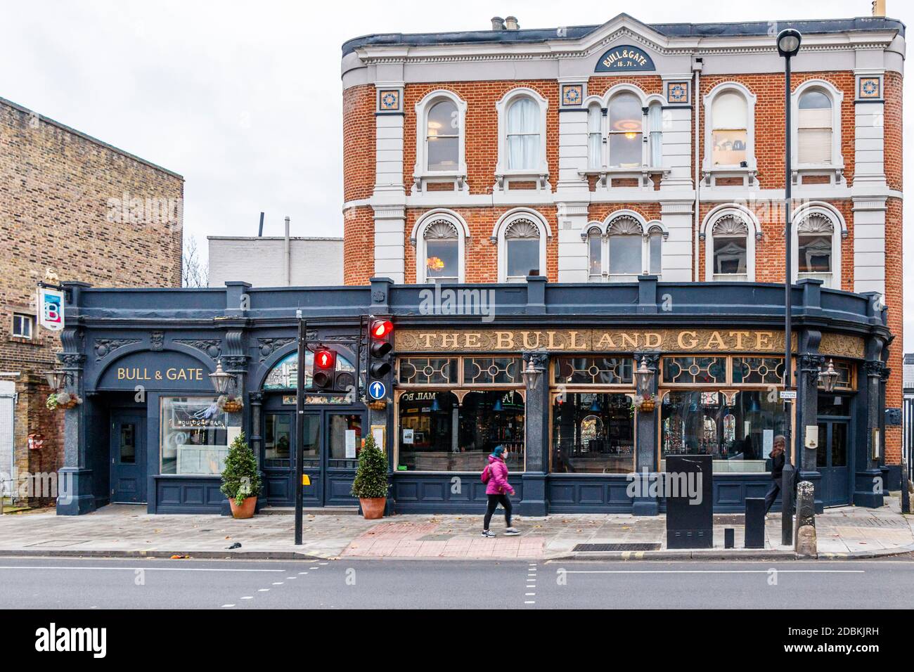 Eine Frau spaziert vorbei am Bull and Gate Pub, bekannt als Live-Musik, Kentish Town, London, Stockfoto