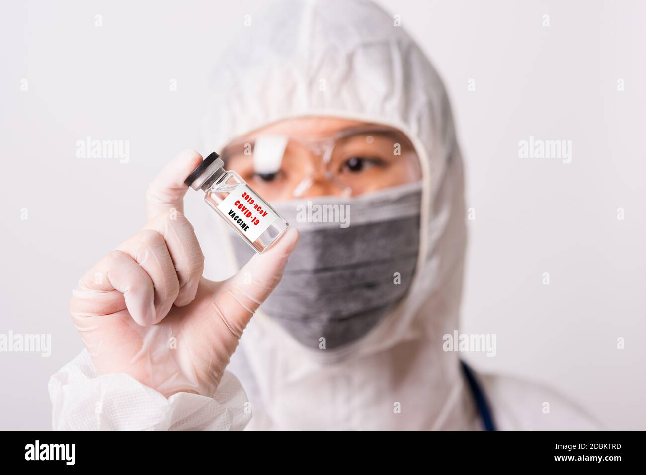 Asiatische Frau Arzt oder Krankenschwester in PSA Uniform und Handschuhe tragen Gesichtsmaske Schutz im Labor hält Medizin Fläschchen Coronavirus Impfstoff Bott Stockfoto