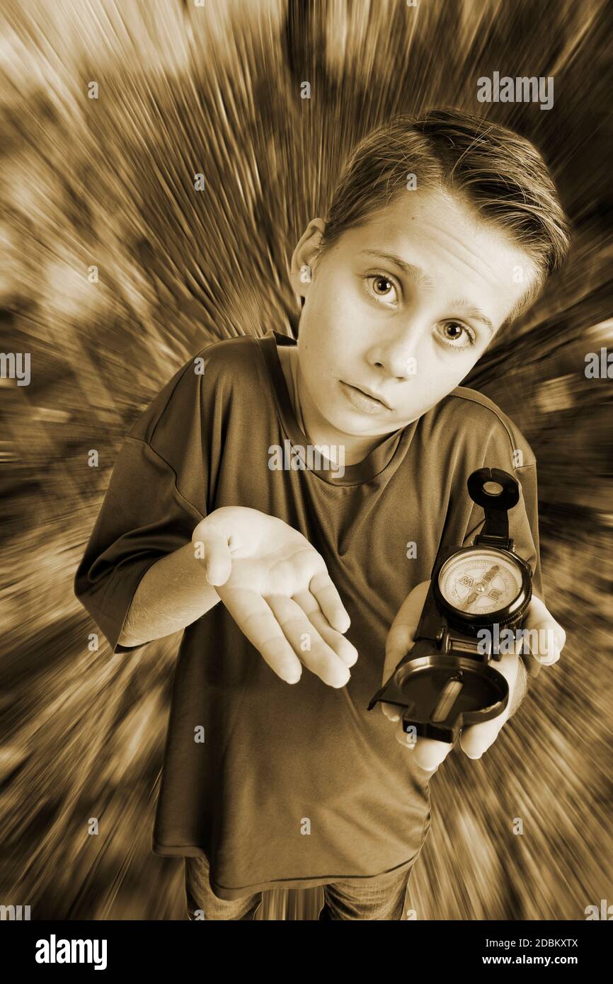 Monochrom-Bild eines 12-jährigen kaukasischen Jungen in einer erhöhten, Weitwinkel Dreiviertel-Ansicht mit einem Kompass auf der linken Hand, Blick auf die Kamera h Stockfoto
