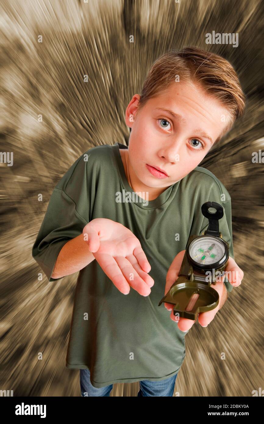 Bild eines 12-jährigen kaukasischen Jungen in einer erhöhten, Weitwinkel-Dreiviertel-Ansicht mit einem Kompass auf der linken Hand, Blick auf die Kamera hilflos ein Stockfoto