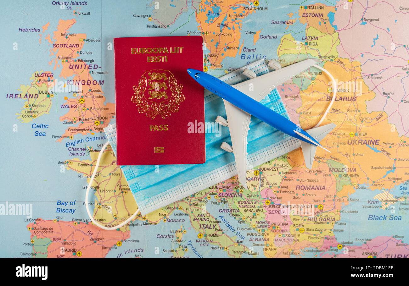 Spielzeug eines Flugzeugs, medizinische Maske und Reisepass auf der Europakarte. Stockfoto