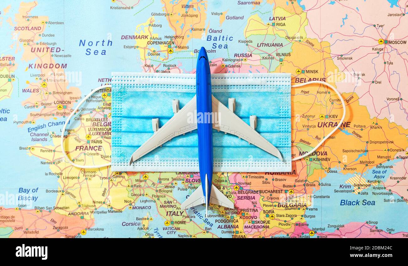 Spielzeug eines Flugzeugs und medizinische Maske auf der Europakarte. Stockfoto