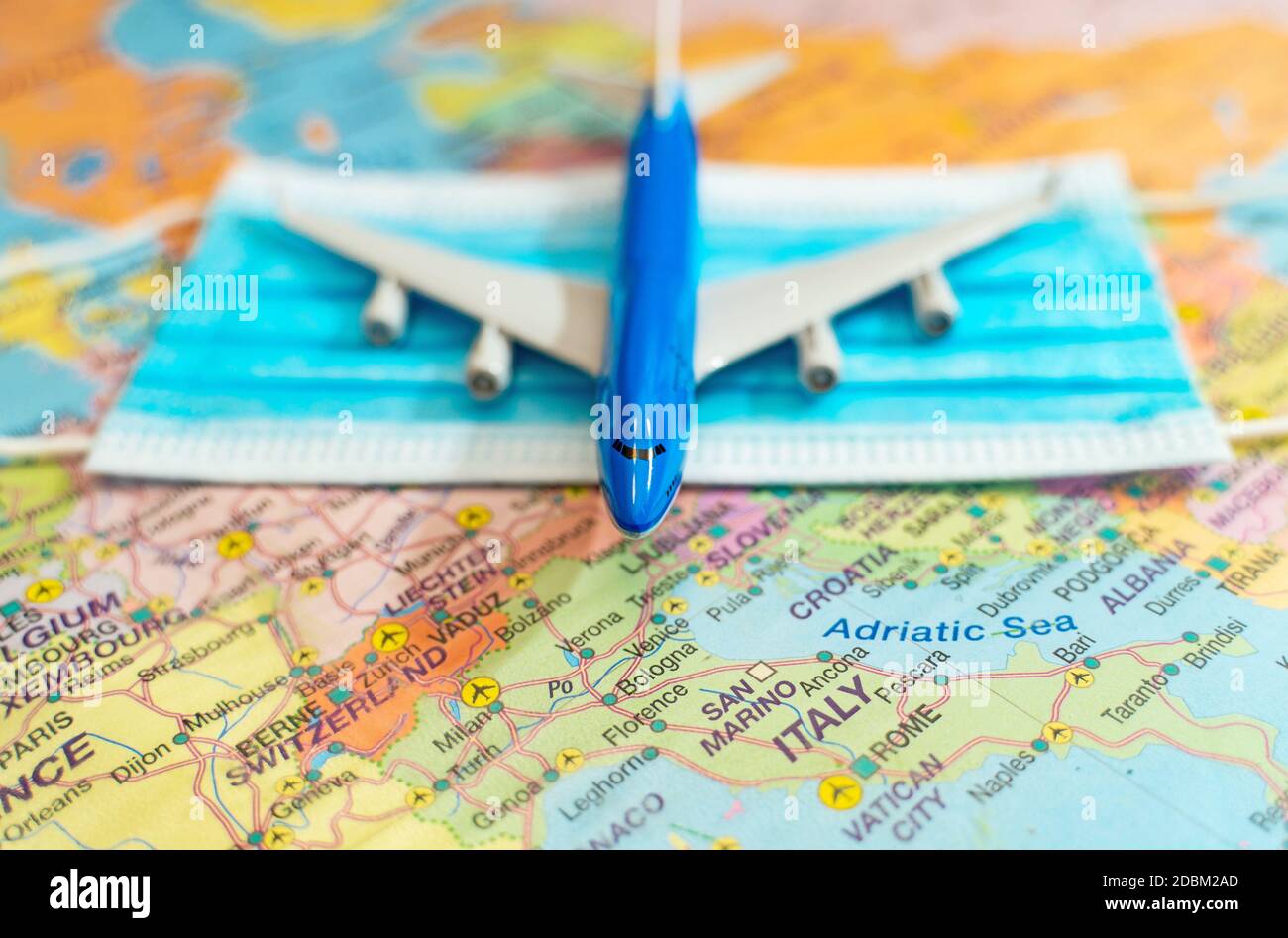 Spielzeug eines Flugzeugs und medizinische Maske auf der Europakarte. Stockfoto
