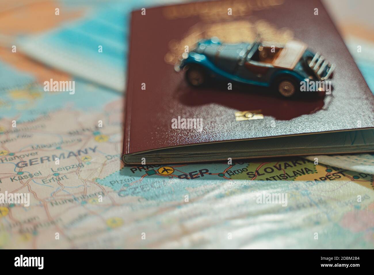 Spielzeug eines Autos, medizinische Maske und Reisepass auf der Europakarte. Stockfoto