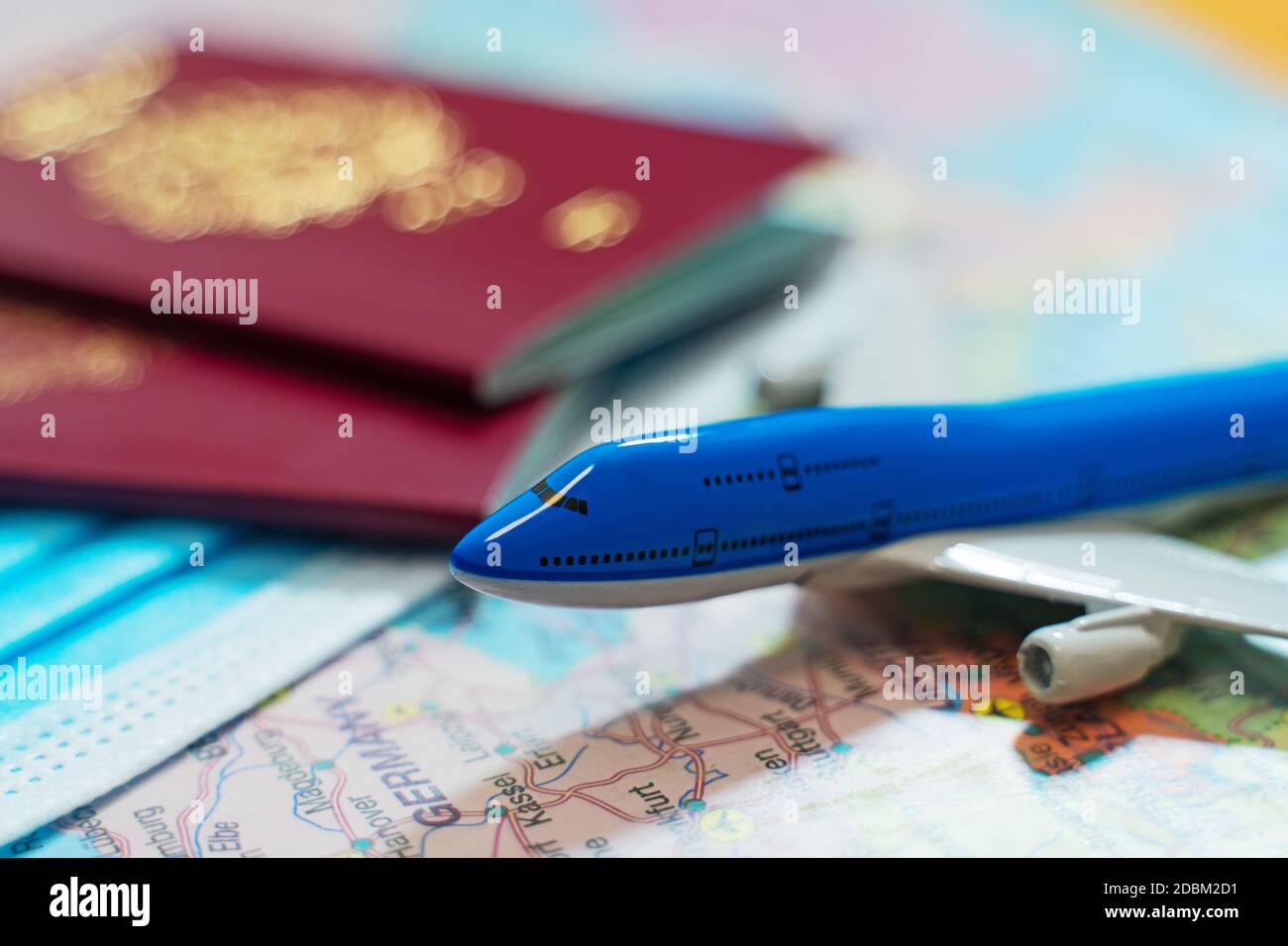Spielzeug eines Flugzeugs, medizinische Maske und Pässe auf der Europakarte. Stockfoto
